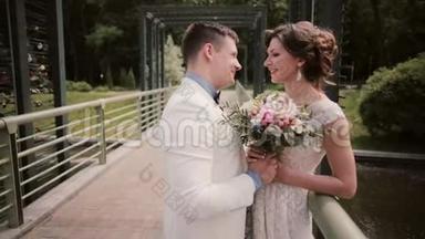 在婚礼那天看到一对美丽的恋人。 新娘穿着白色婚纱，新郎穿着婚纱在桥上